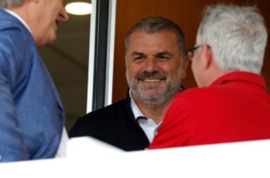 Ange Postecoglou smiles during a conversation